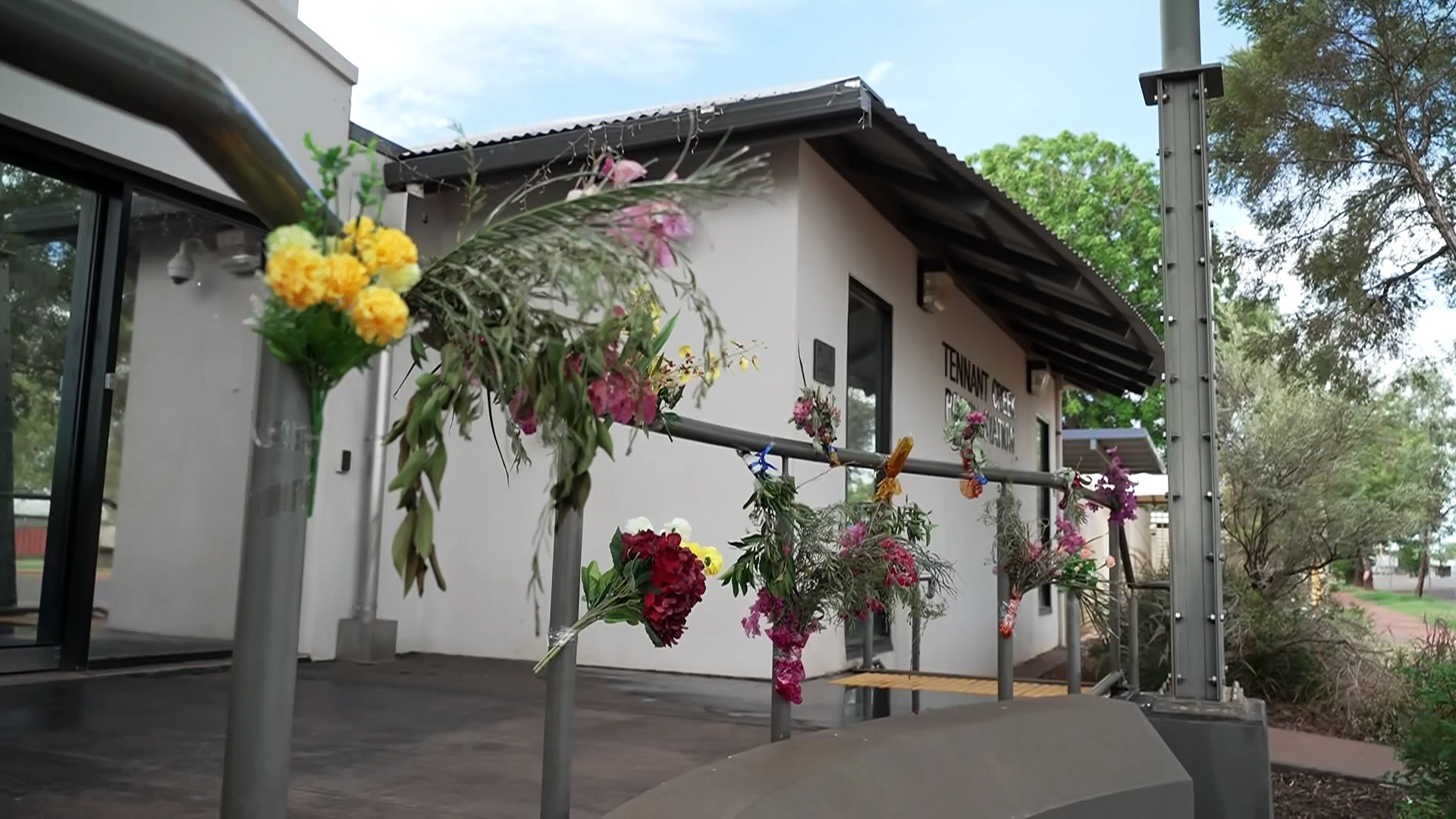 Community lays flowers outside police watch house to remember ...