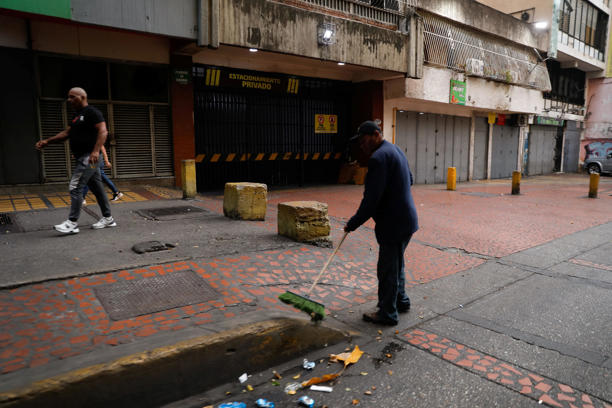 A man sweeps the street, after U.S. President Donald Trump said the U.S. has struck Venezuela and captured its President Nicolas Maduro, in Caracas, Venezuela, January 3, 2026.