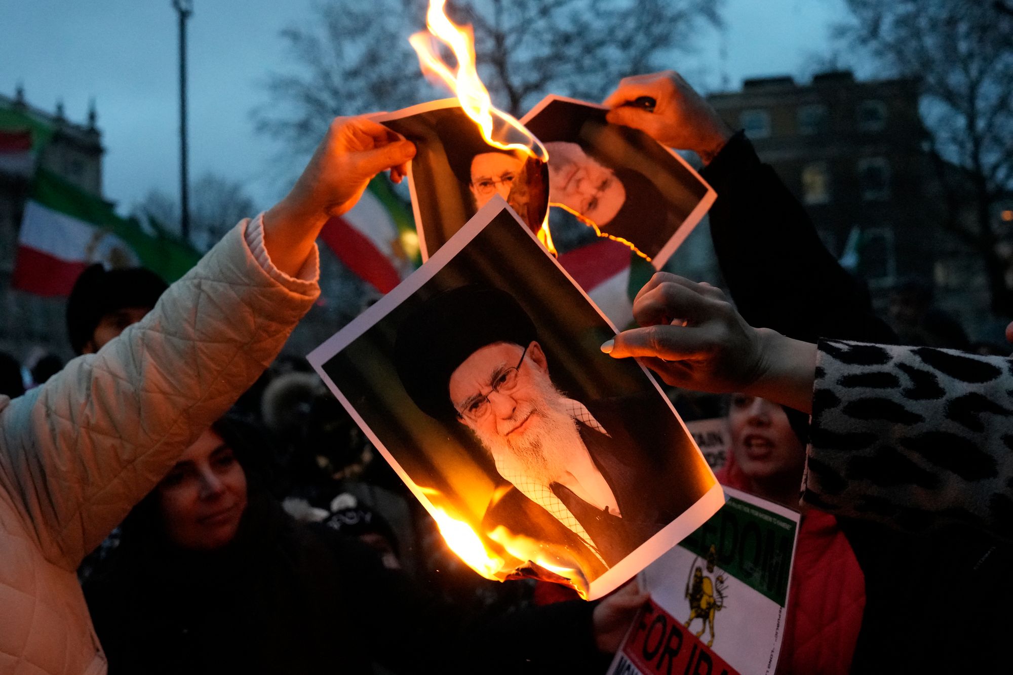 Protestors burn images of Iran's supreme leader Ayatollah Ali Khamenei (Carlos Jasso/AFP via Getty Images)
