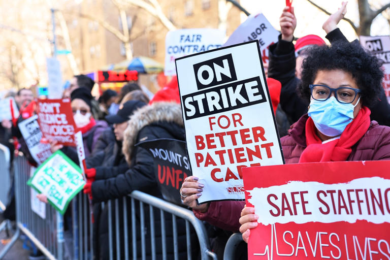 Michael M. Santiago/Getty Images - Nurses from Mount Sinai Hospital strike outside the hospital on Jan. 09, 2023, in the Upper East Side neighborhood of New York City