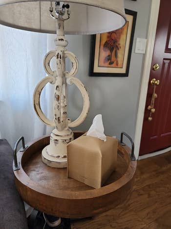 another reviewer's beige tissue box cover on a side table next to a lamp