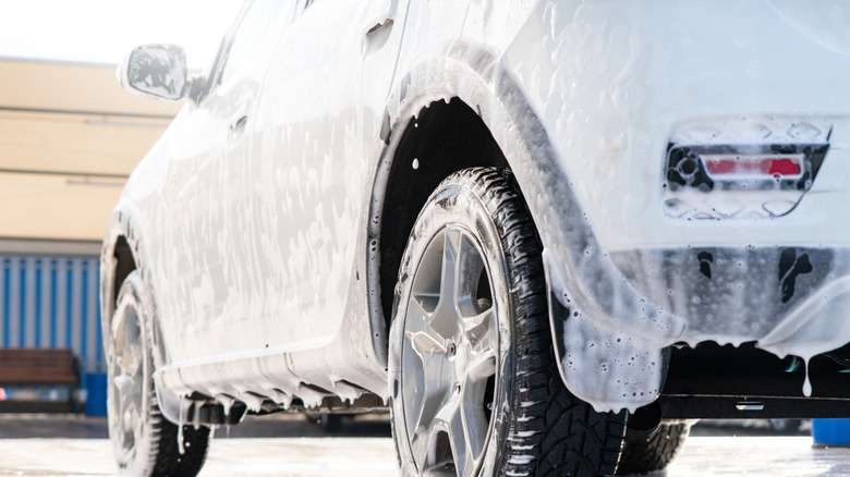 A vehicle covered with cleaning foam at a car wash