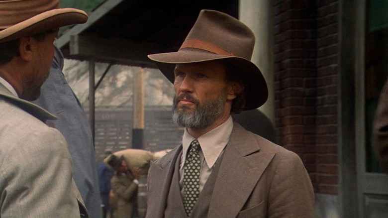 James Averill (Kris Kristofferson) looks sternly at someone speaking to him in Heaven's Gate