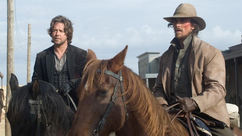 Ben Wade (Russell Crowe) and Dan Evans (Christian Bale) sit on horses in a Western town in 3:10 to Yuma (2007)