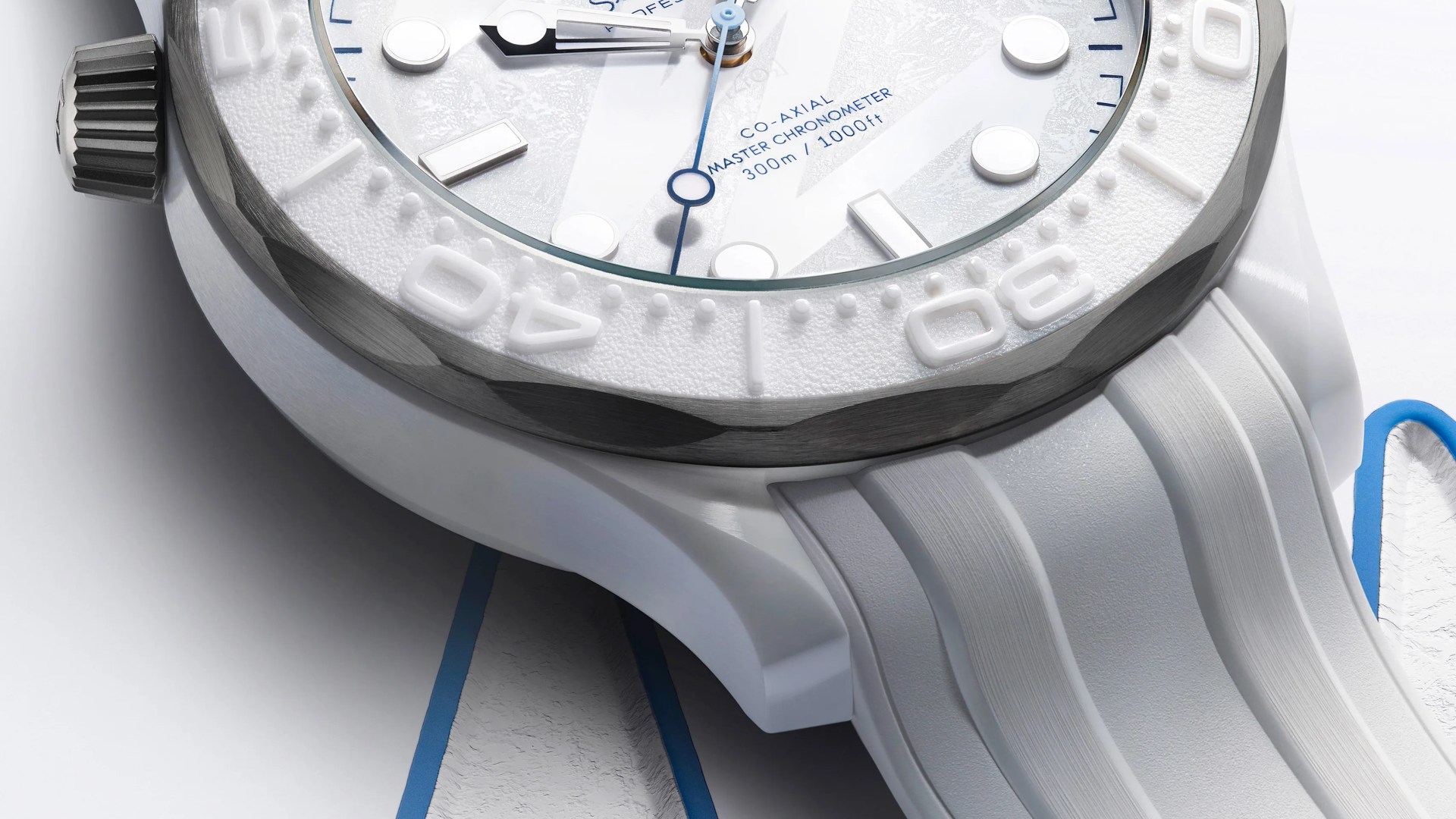 Close-up of a white dive watch with textured bezel, blue second hand, and white rubber strap.