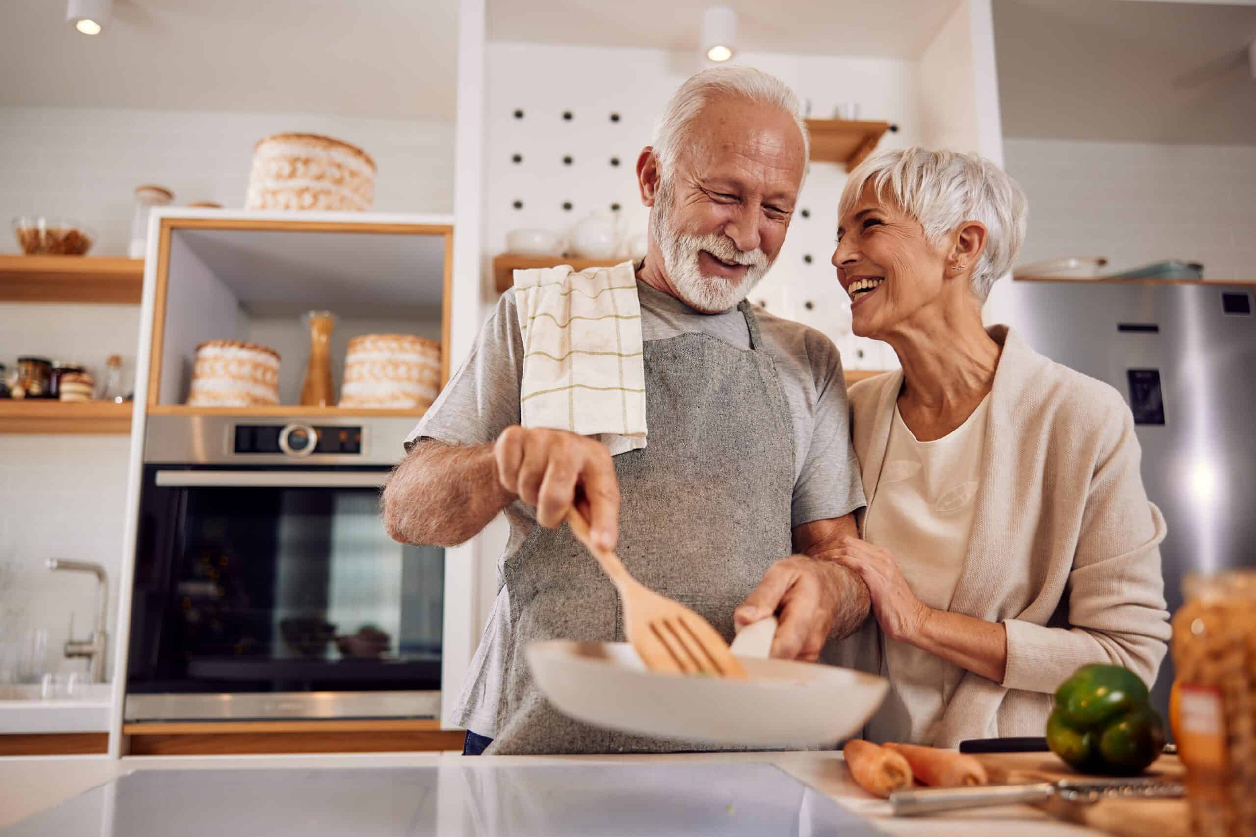 Baby Boomers | An older couple cooking a healthy vegan meal with vegetables together