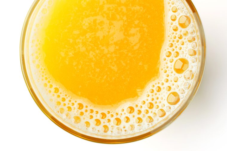 glass of fresh orange juice isolated on white background, top view