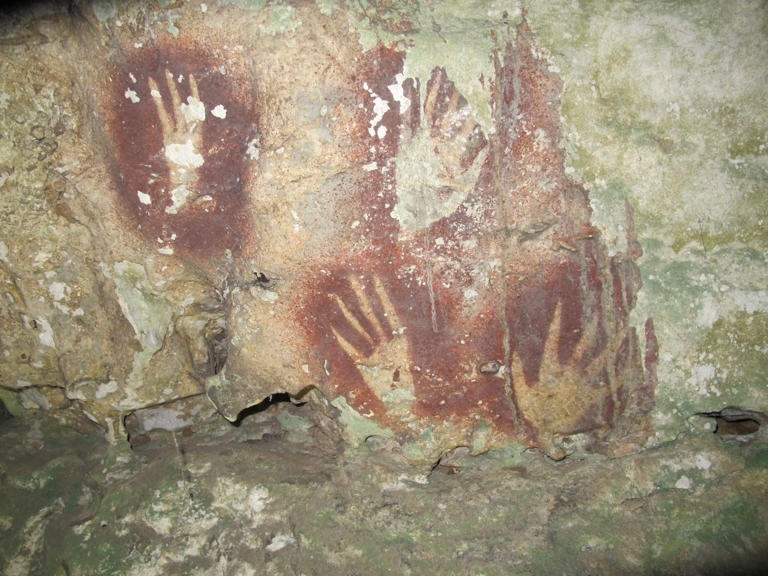 This undated image provided by Maxime Aubert shows handprints with sharpened fingertips in the Maros region of Sulawesi, Indonesia. (Ahdi Agus Oktaviana/Maxime Aubert via AP)