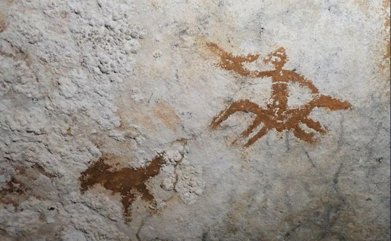 Casi imperceptible, entre las dos imágenes se halla la mano pintada hace 67.800 años. Foto: La Nación / GDA