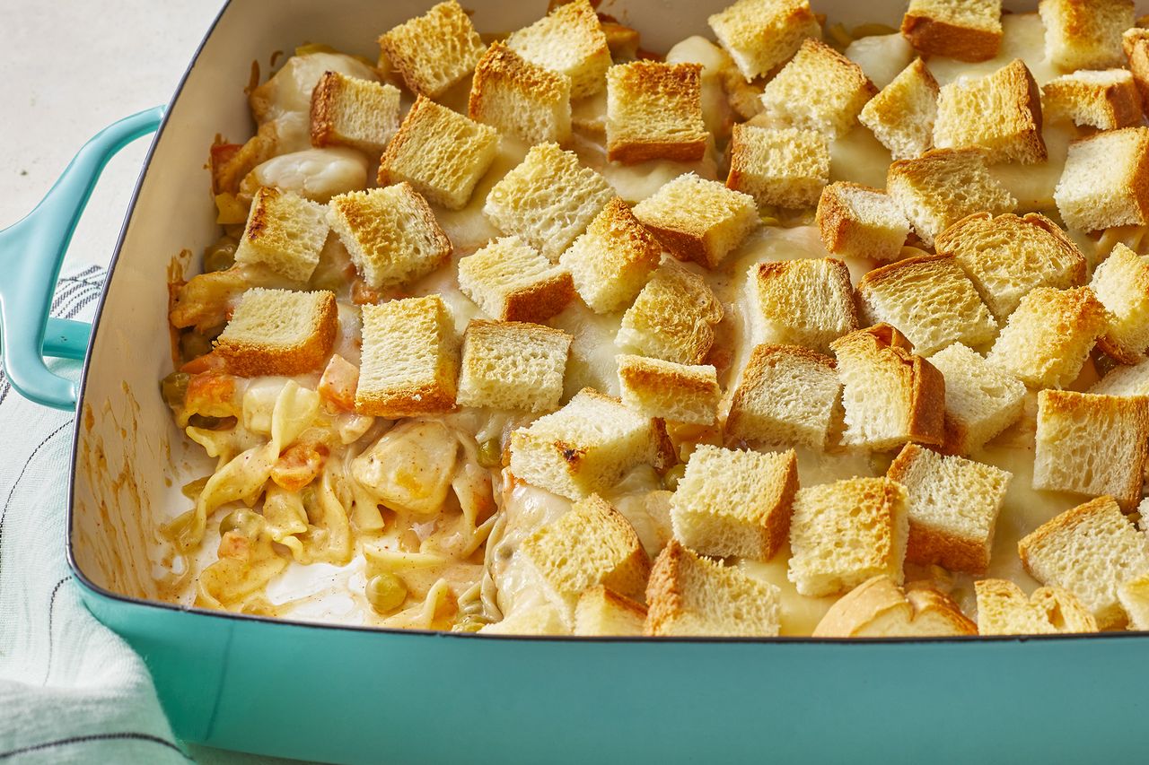 a close up view looking into the corner of a teal baking dish of cheap chicken noodle casserole