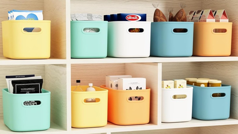 Pantry shelves lined with colored plastic bins holding food