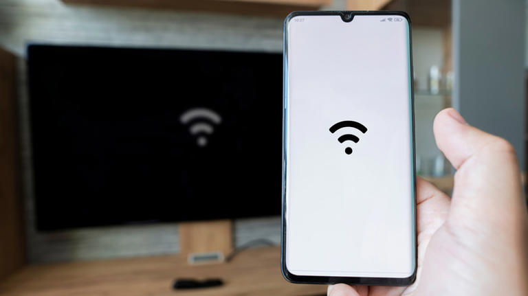 Wifi symbol on a smartphone and on a TV screen in the background