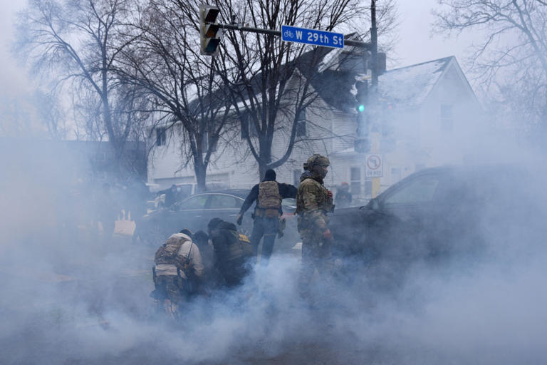 Leah Millis/Reuters - PHOTO: Federal agents hold a person down as they are surrounded by tear gas used to deter protesters in Minneapolis, Minnesota, January 21, 2026.