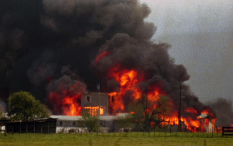Fire engulfs the Branch Davidian compound near Waco, Texas, on April 19, 1993, in which roughly 80 people died.
