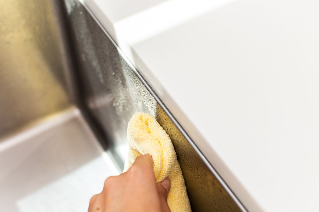 Yellow microfiber cloth drying stainless steel sink