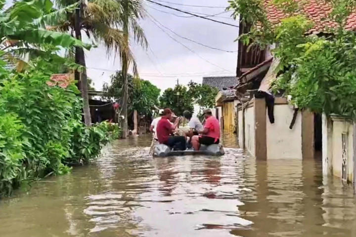 Warga menaiki perahu untuk menerjang banjir di perumahan subsidi Bekasi. Foto: Dok. Istimewa