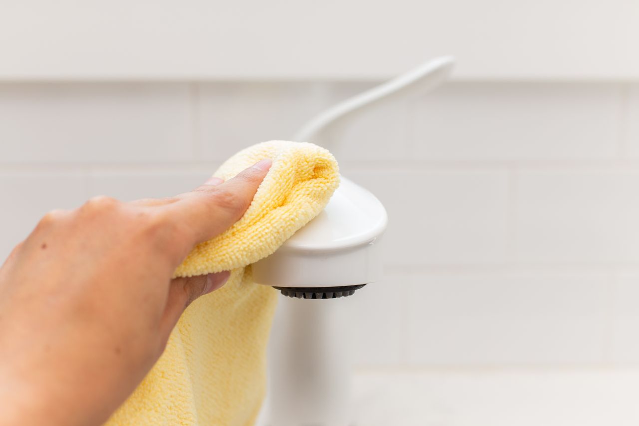 Yellow microfiber cloth buffing sink faucet with coconut oil