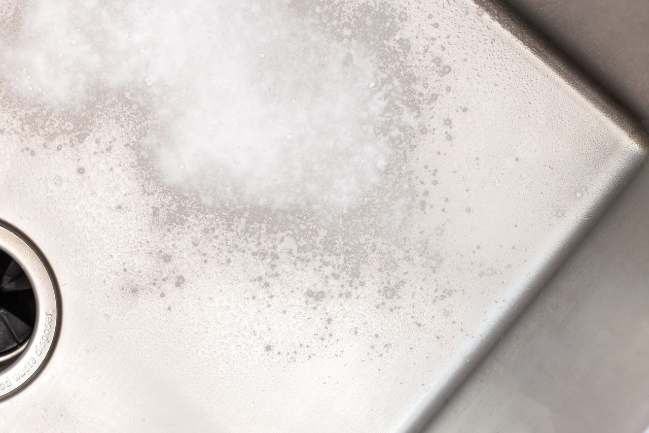 Baking soda coating stainless steel sink to remove stuck food