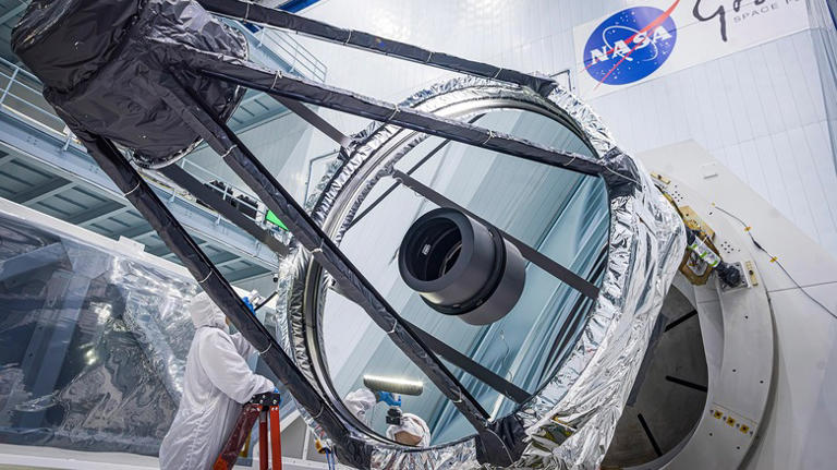 An engineer inspecting the primary mirror for NASA's Nancy Grace Roman Space Telescope
