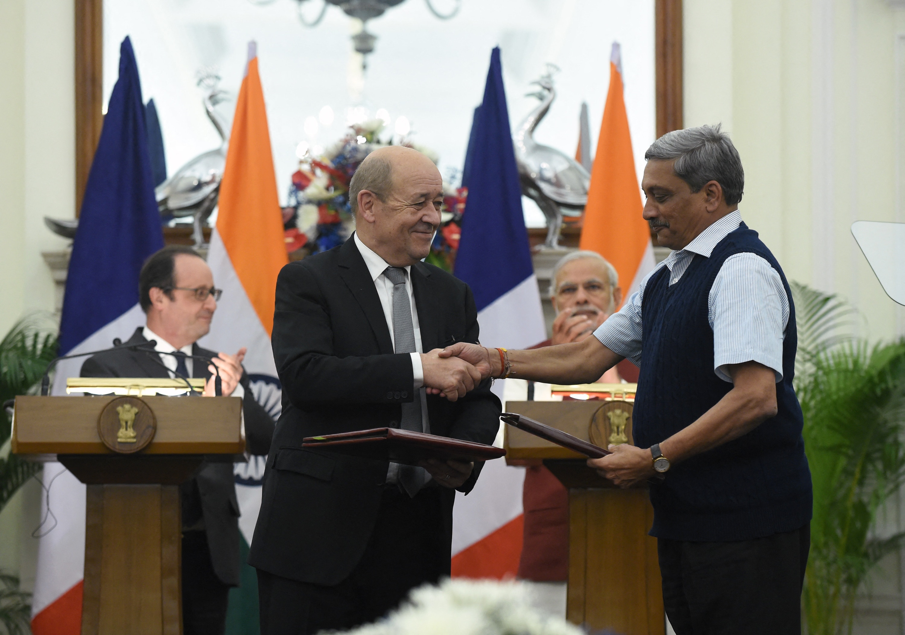 Then Indian Defence Minister Manohar Parrikar and his French counterpart exchanging agreements for the purchase of 36 Rafale jets at a joint press conference between Prime Minister Narendra Modi and then French President Francois Hollande in New Delhi on January 25, 2016 (Photo: AFP)