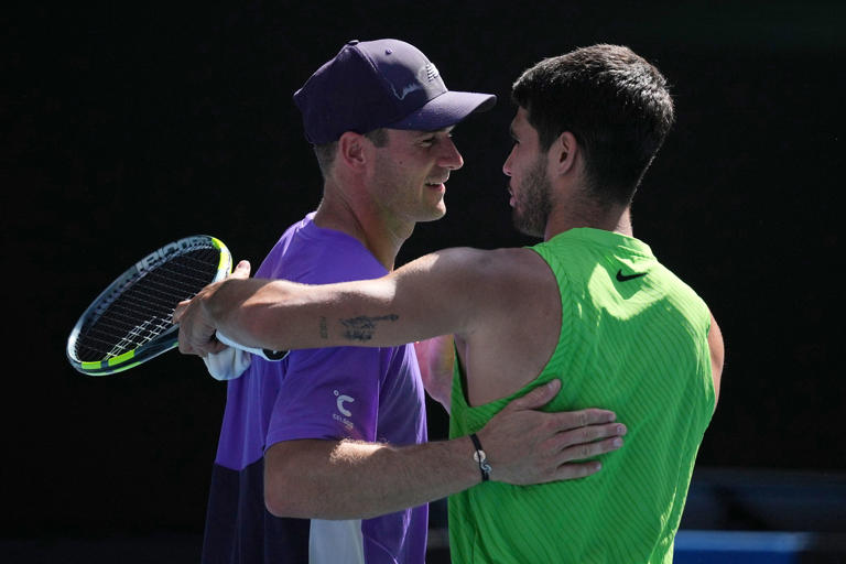 Carlos Alcaraz, right, of Spain is congratulated by Tommy Paul, left, of the U.S. during their fourth round match at the Australian Open tennis championship in Melbourne, Australia, Sunday, Jan. 25, 2026. (AP Photo/Dita Alangkara)