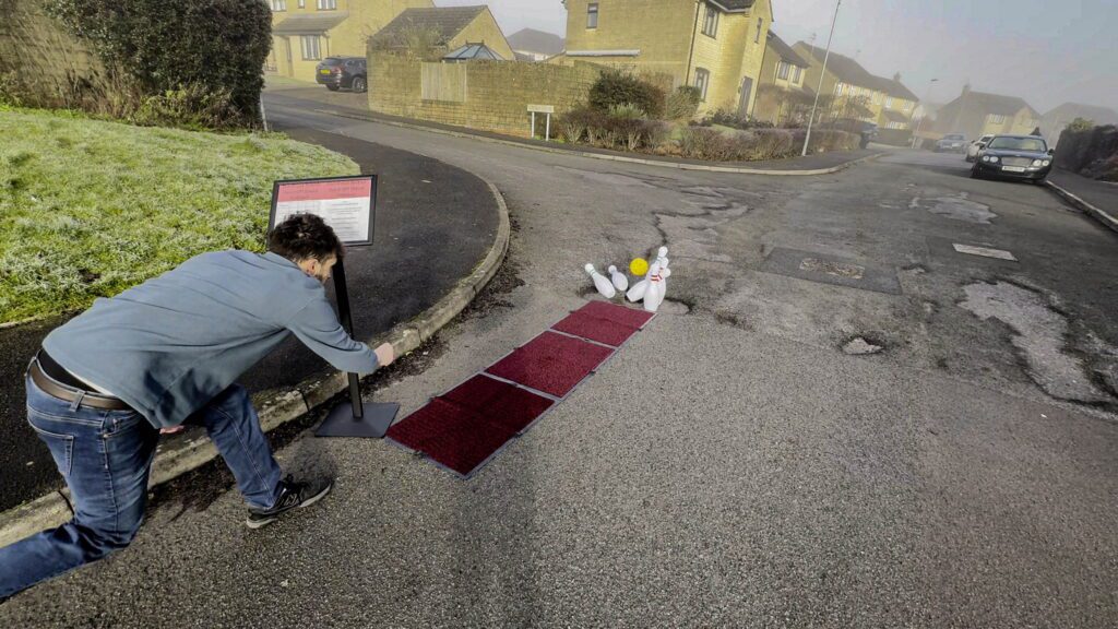 Man protests to fix Britain’s roads – by filling pothole with bowling pins