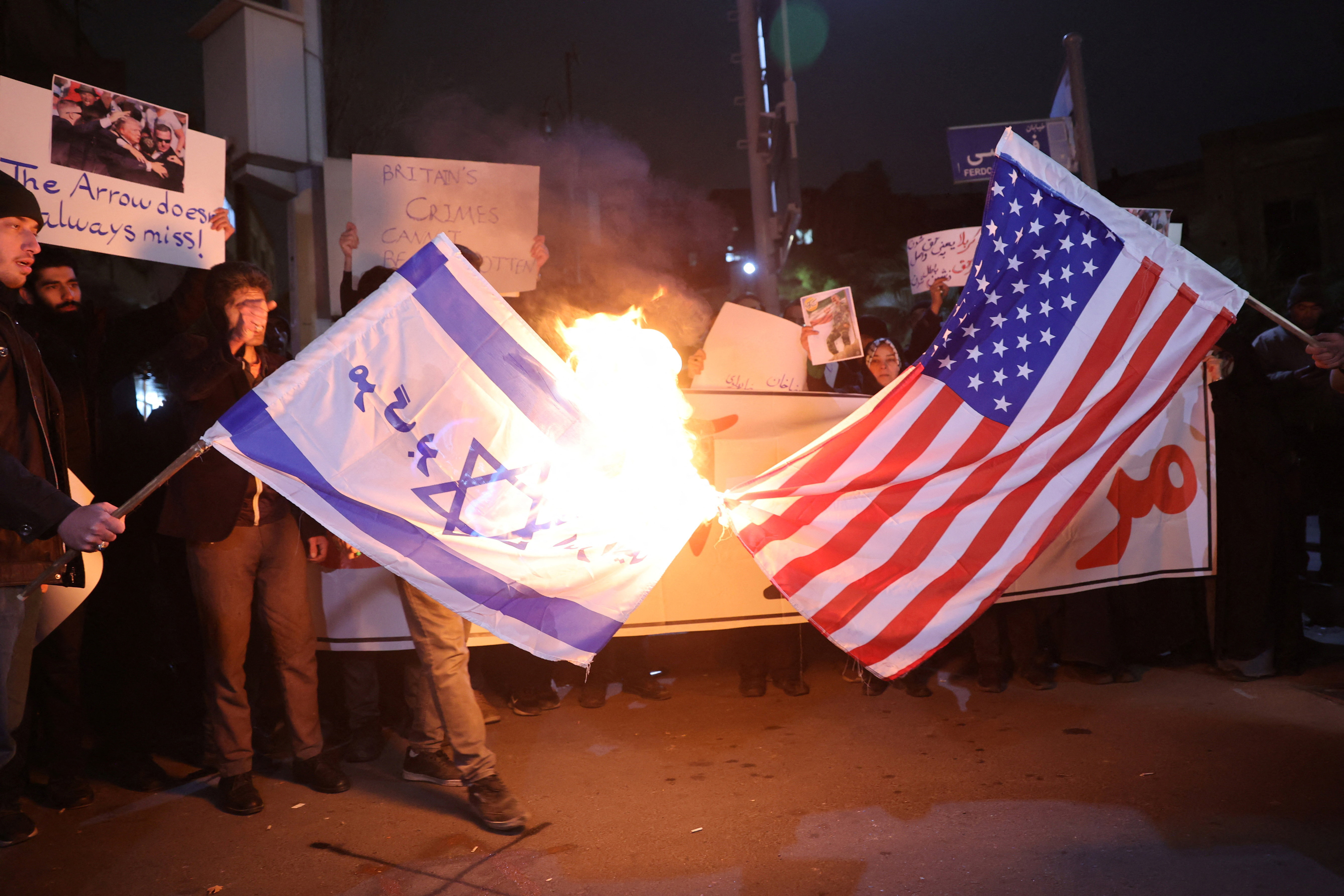 14일(현지시간) 이란 테헤란에서 반정부 시위에 항의하는 이란 학생들이 영국 대사관 앞에서 미국과 이스라엘 국기를 불태우고 있다. 2026.1.14 WANA 로이터 연합뉴스 로이터=연합뉴스