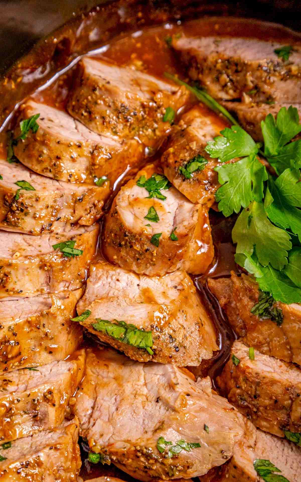 Cut up pork tenderloin slices in a slow cooker with sauce.