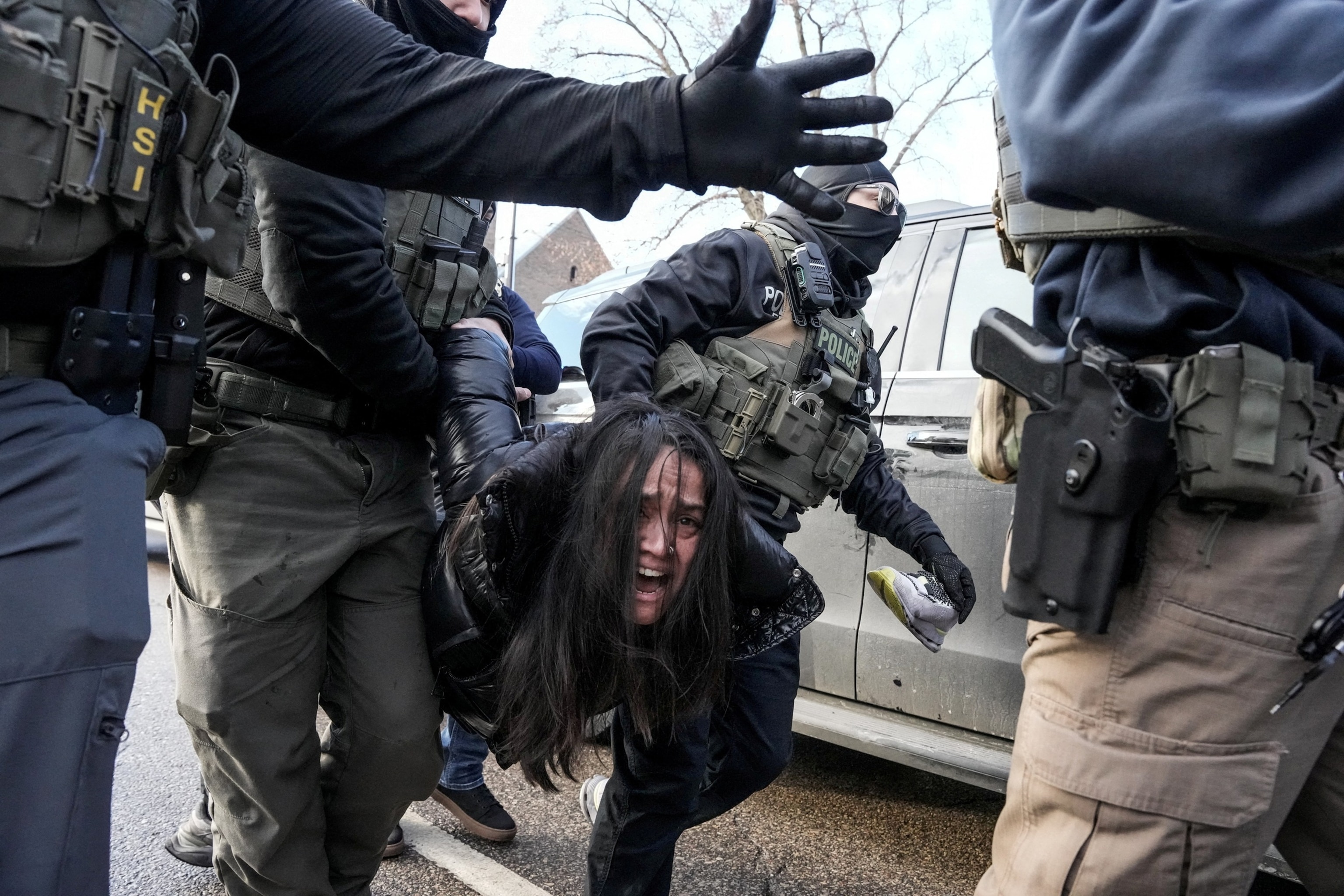 Tim Evans/Reuters - PHOTO: Federal agents detain a woman after pulling her from a car, January 13, 2026 in Minneapolis, Minnesota.