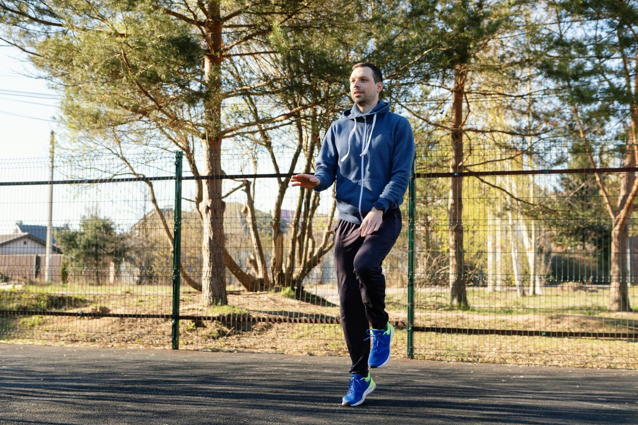 High knees exercise, man preparing for sports training