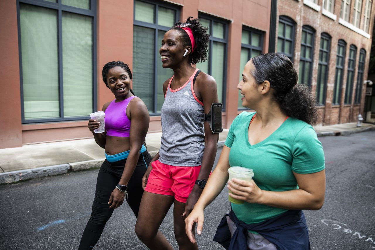 Female runners walking with coffee after a workout