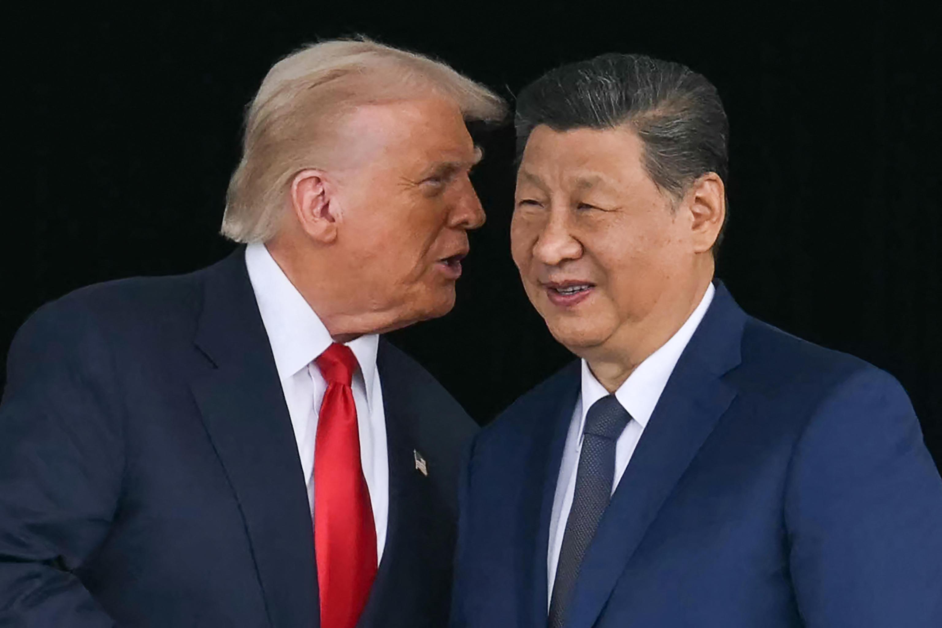 US President Donald Trump (L) talks to China's President Xi Jinping as they shake hands after their talks at the Gimhae Air Base, located next to the Gimhae International Airport in Busan on October 30, 2025. US President Donald Trump and China's leader Xi Jinping opened on October 30 their first face-to-face meeting in six years, seeking a truce to end a trade war that has roiled the world economy. (Photo by ANDREW CABALLERO-REYNOLDS / AFP)