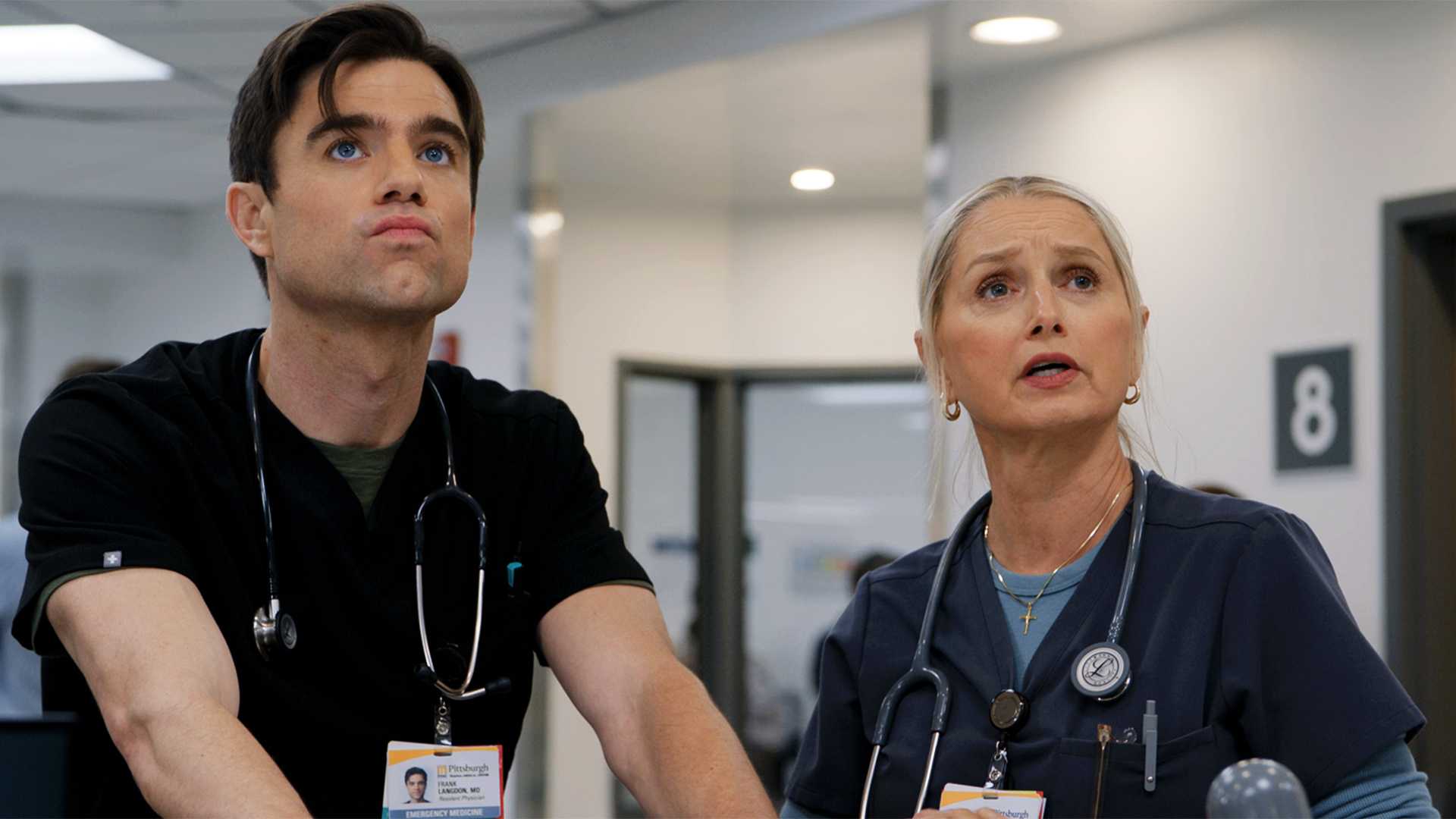 Langdon and Dana standing together and looking ahead together in an episode of The Pitt