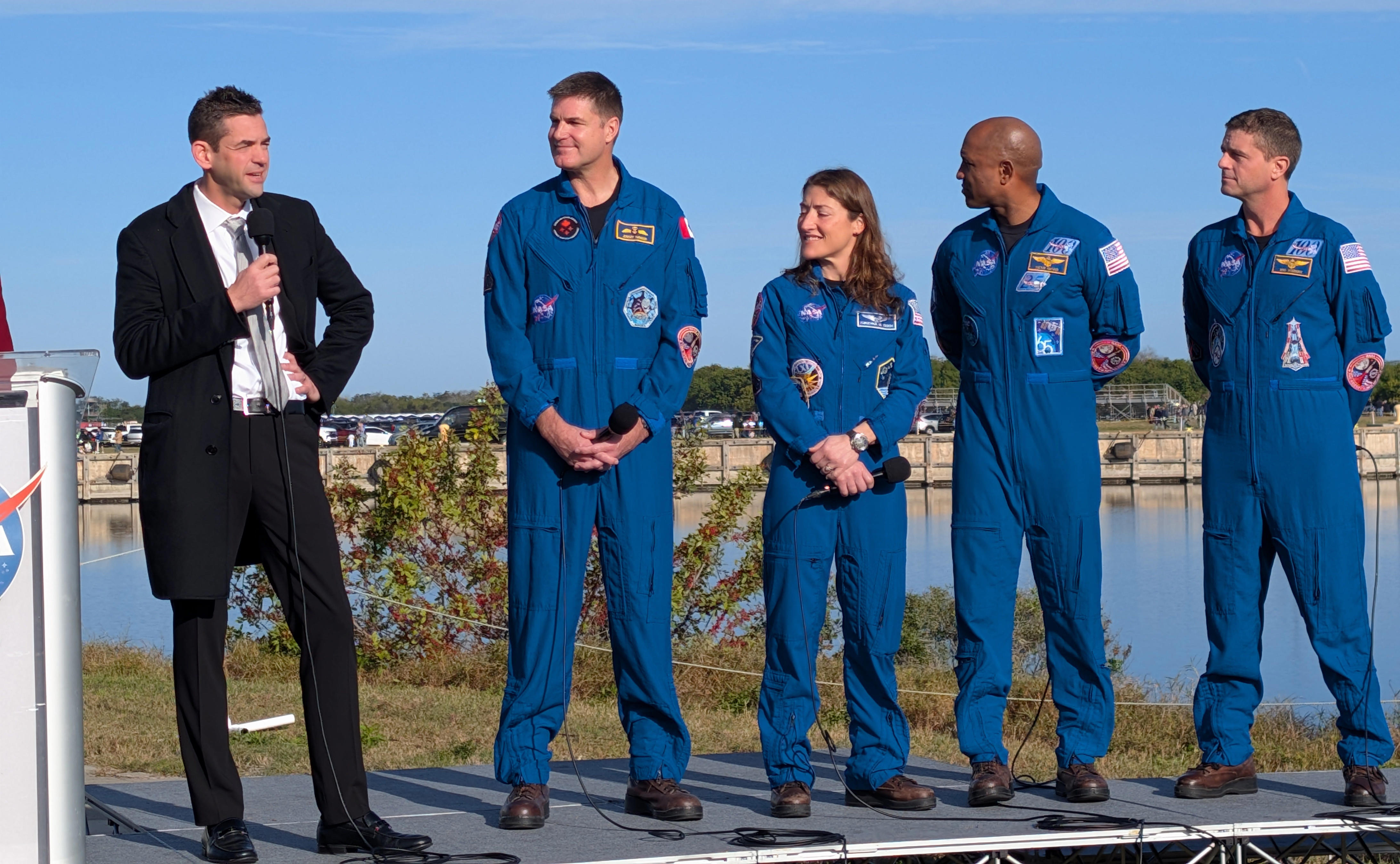 NASA Administrator Jared Isaacman stands with the Artemis II crew during an SLS rollout press briefing.