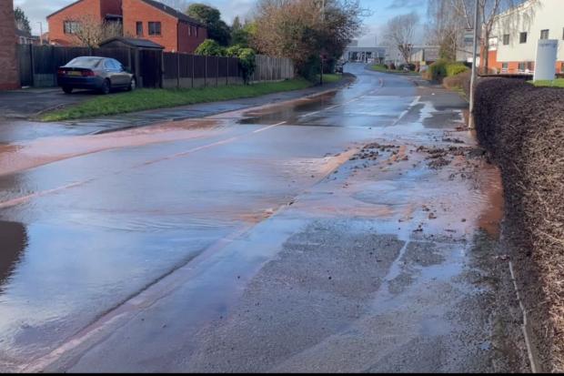 Burst water main causes flooding and delays on busy road