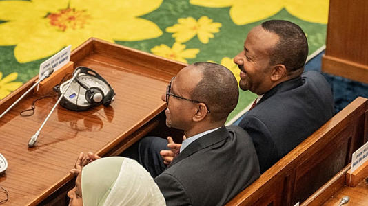 Le Premier ministre éthiopien Abiy Ahmed Ali, à droite, sourit,  aux côtés d'Adem Farah, au centre, vice-président du Parti de la prospérité au pouvoir.