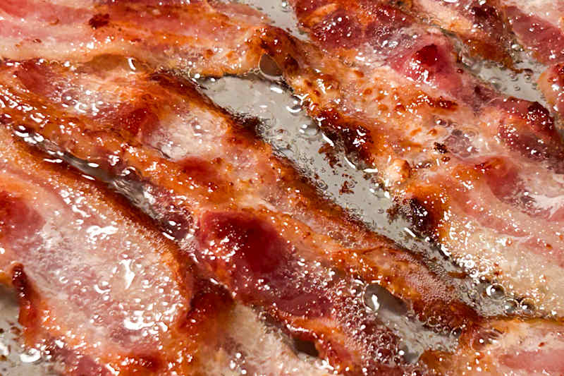 Bacon cooking in water.