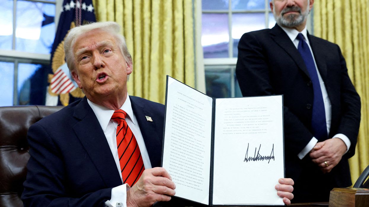 FILE PHOTO: U.S. President Donald Trump holds a signed executive order on tariffs on aluminum imports in the Oval Office of the White House in Washington, U.S., February 10, 2025. REUTERS/Kevin Lamarque//File Photo