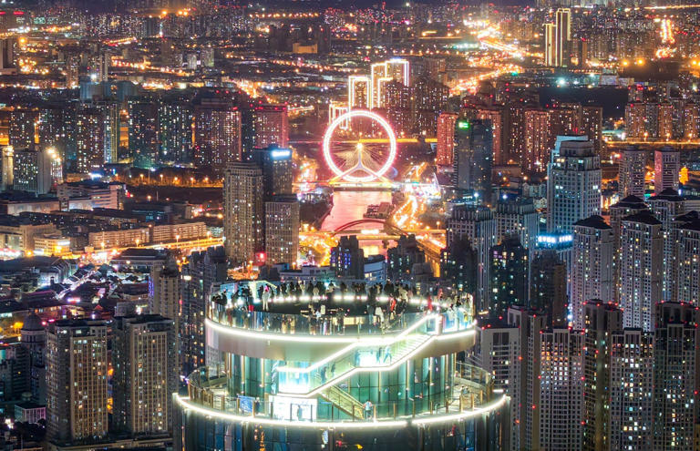 Visitors to the Jinwan Yunding sightseeing deck in the Heping district of Tianjin, north China, enjoy the night view on December 21. As the global economy expands, global energy demand could rise by around 124 per cent by 2100. Photo: Xinhua