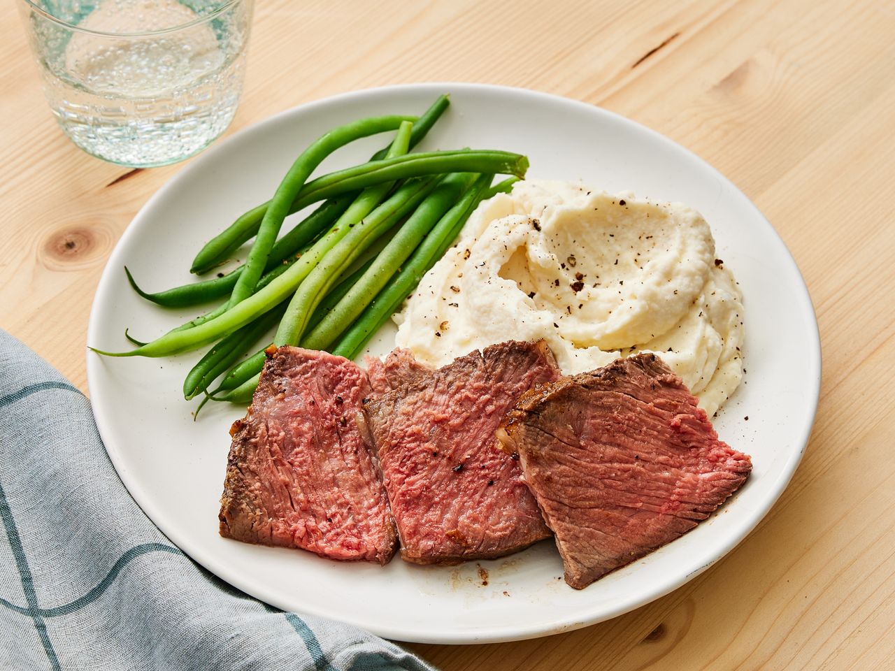 Plate with sliced beef mashed potatoes and green beans