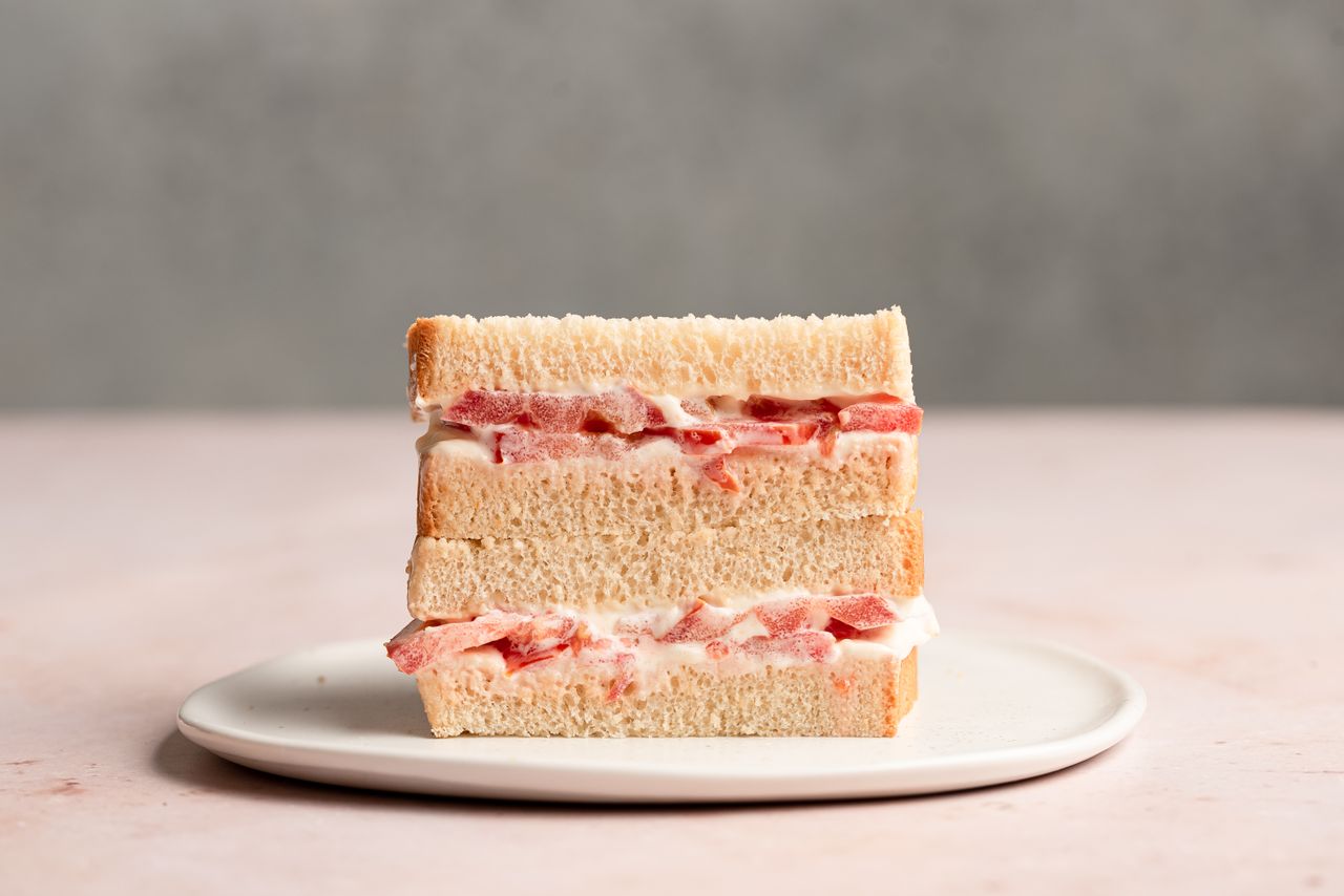 Sliced open southern tomato sandwich on a white plate.