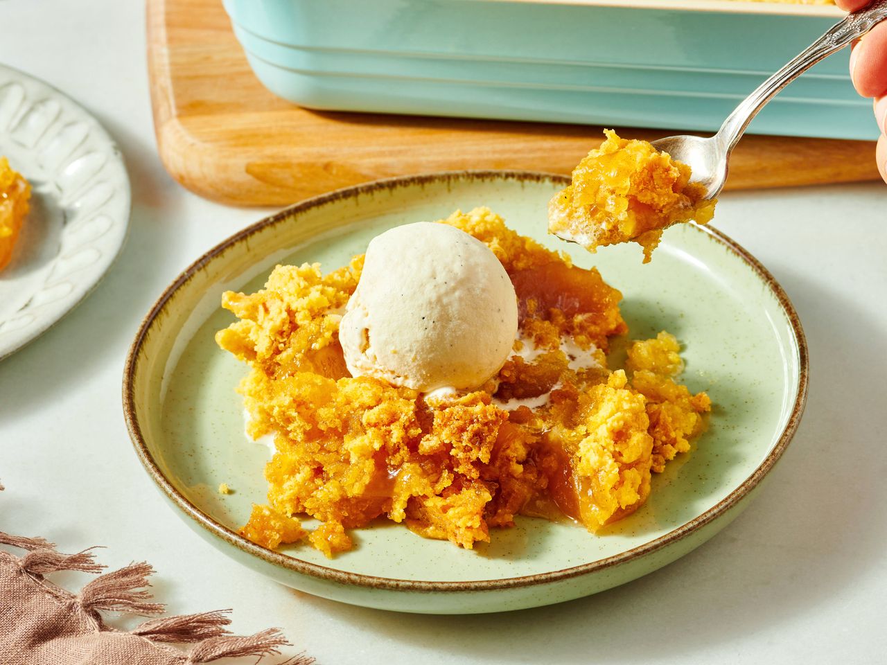 close up on Bible study apple cobbler on a plate, topped with a scoop of vanilla ice cream