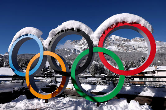 Logo Igrzysk olimpijskich pokryte śniegiem przed Zimowymi Igrzyskami Olimpijskimi 2026 w Mediolanie i Cortinie.