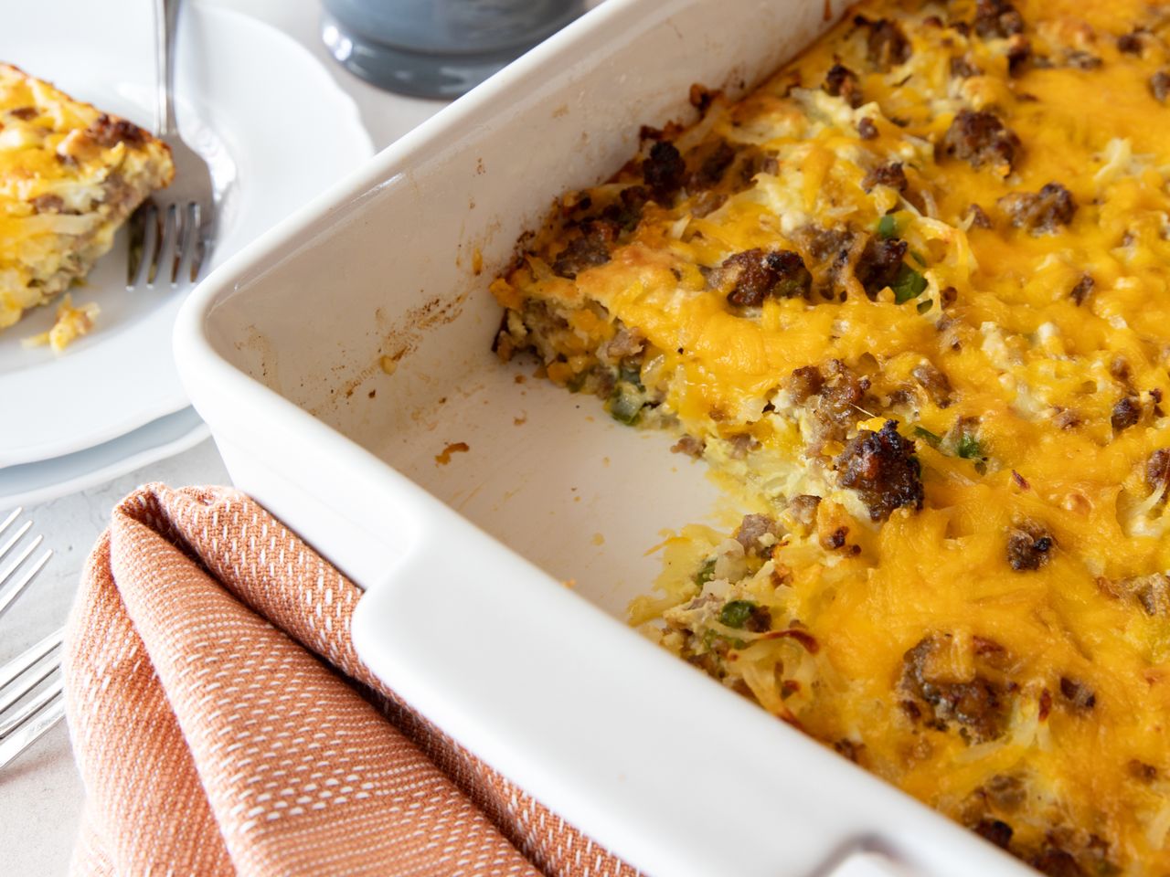 Impossibly Easy Breakfast Bake (Crowd Size) in a baking dish next to a plate with a slice