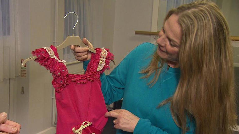 Collins pictured here holding an outfit made by Twigs' mother for her first competition at the age of eight