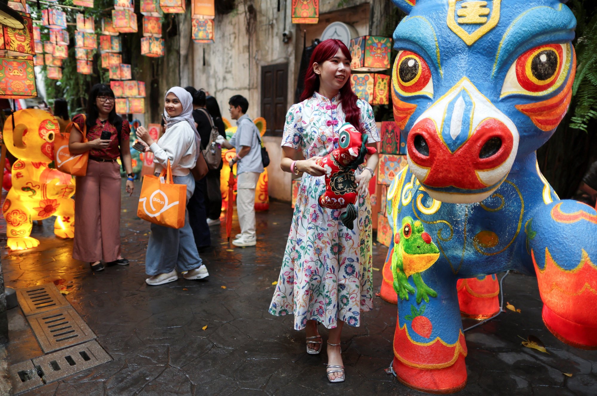 People admire statues representing animals of the Chinese zodiac at the