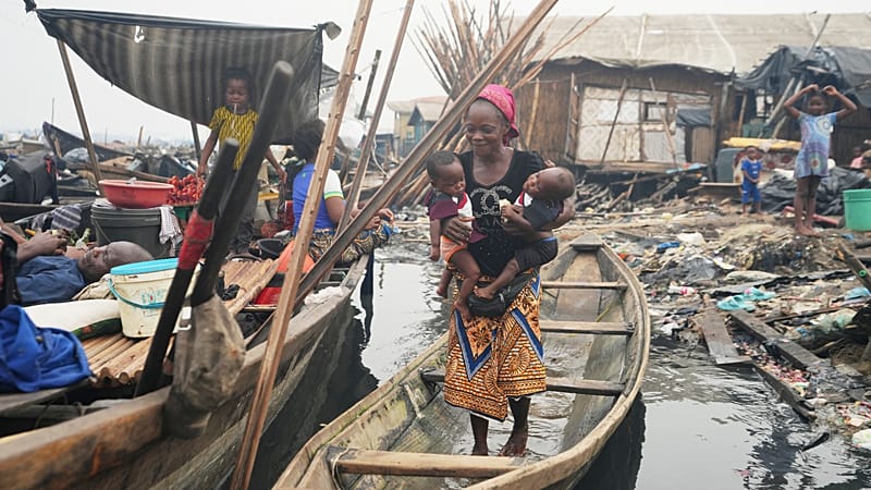 Josianua Agbokpasu poses with her twins inside a canoe in Makoko Lagos, Nigeria, Friday, Jan.30, 2026.
