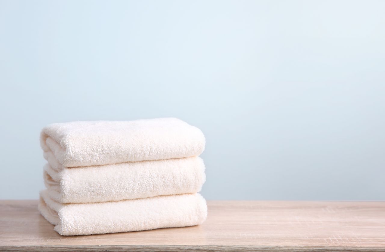 A stack of folded towels on a wooden surface