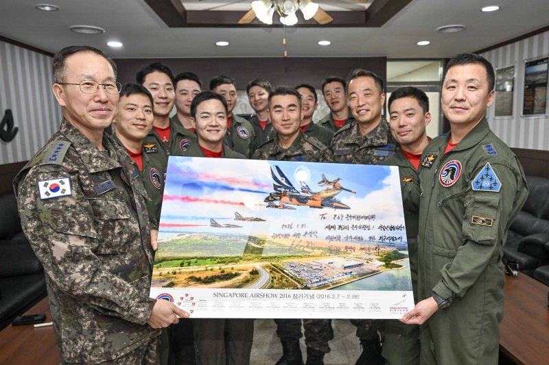 손석락 공군참모총장(왼쪽 첫번째)이 지난달 21일 원주기지를 방문해 사우디 국제방위산업 전시회 2026 참가를 앞둔 블랙이글스 조종사들과 함께 기념액자를 들고 성공적인 임무 완수를 다짐하고 있다. 공군 제공