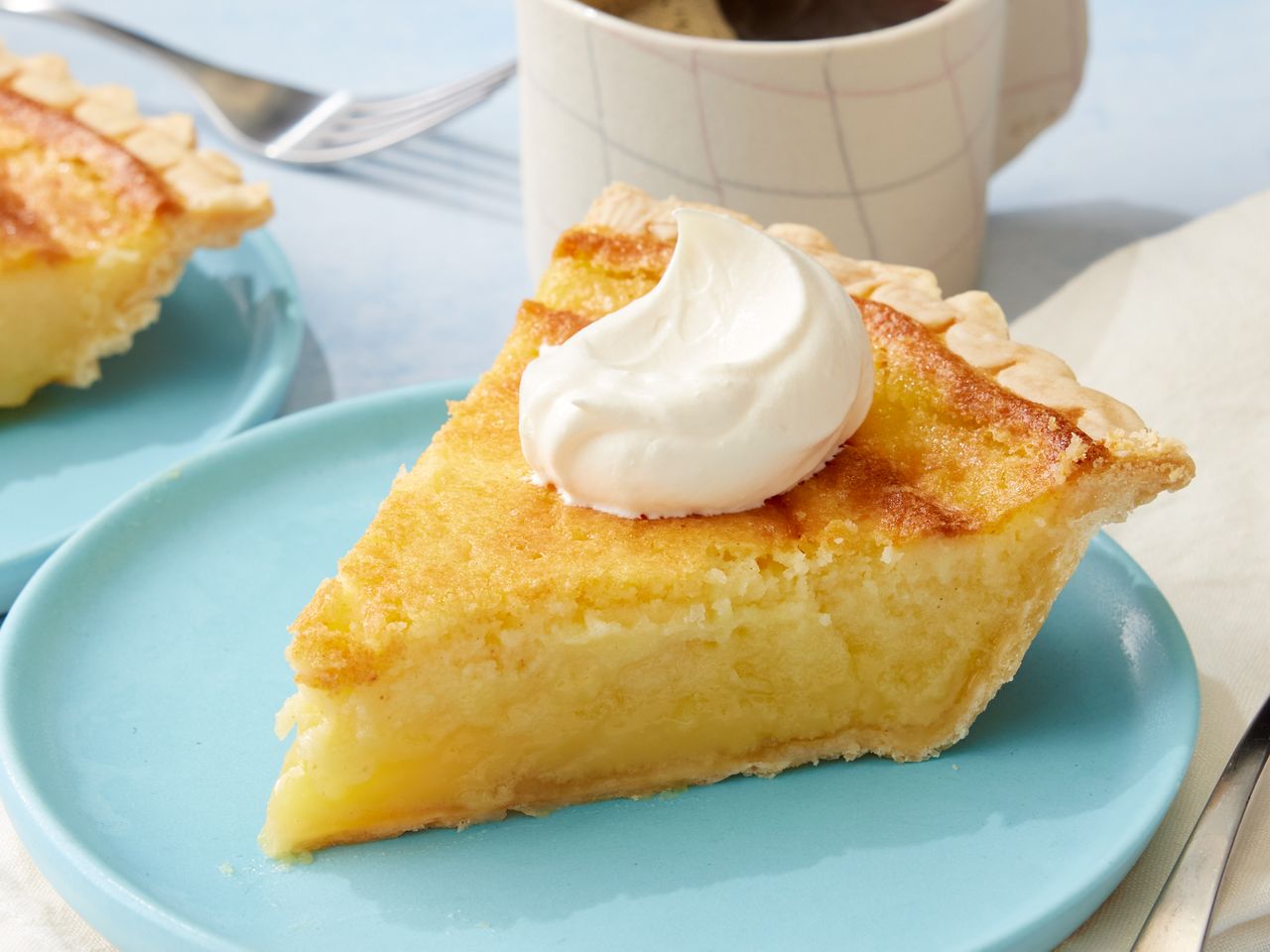 A slice of buttermilk pie topped with whipped cream